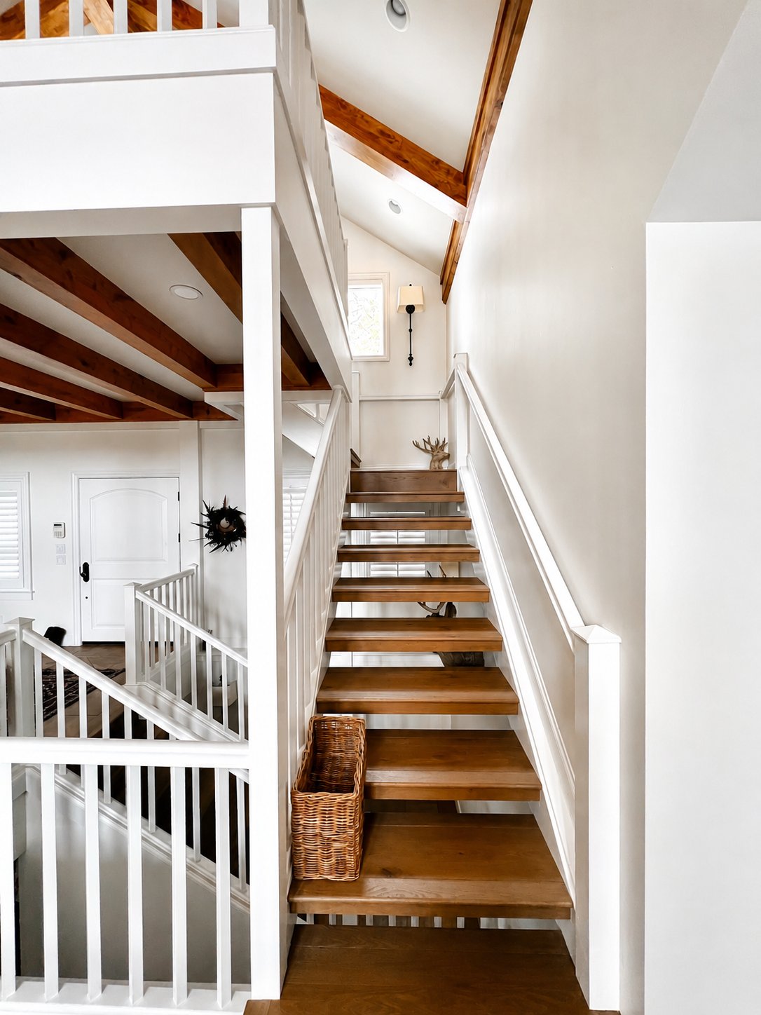 Interior finishing of a custom staircase with natural wood treads and white railings in Northern Nevada