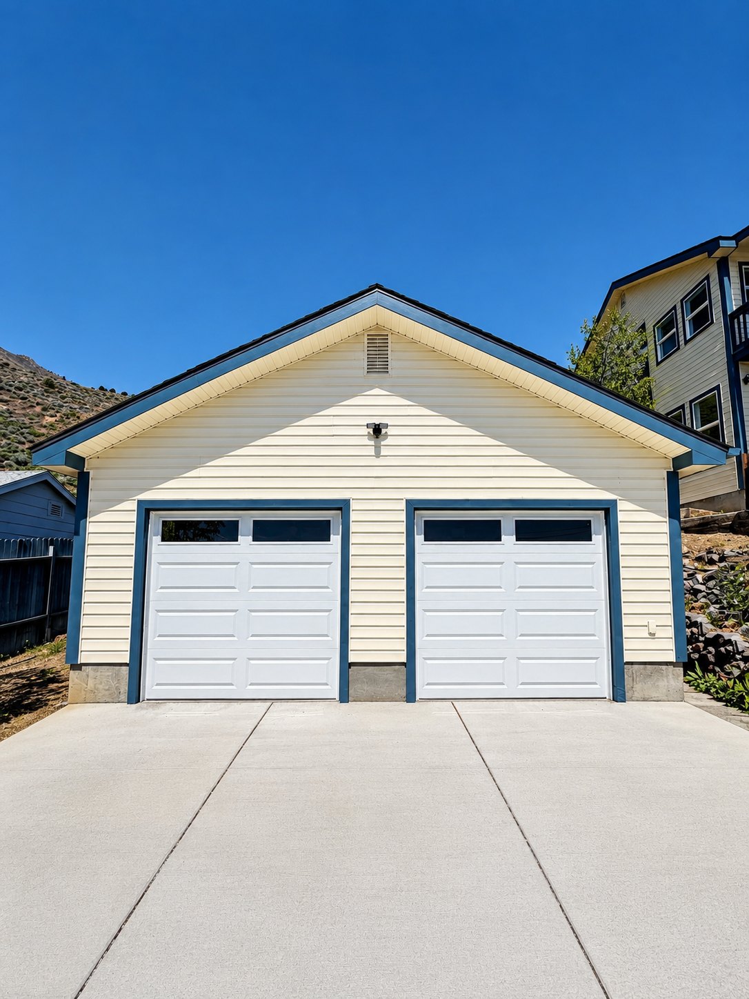 Exterior repaint of a detached garage with fresh white doors and trim in Northern Nevada