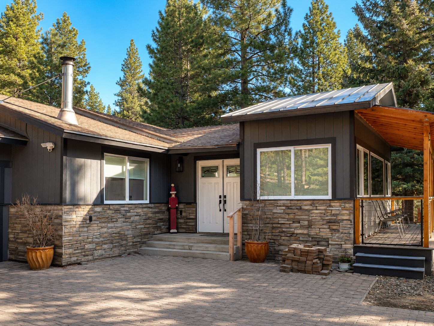 Exterior repaint of a warm-gray mountain home with stone accents and deck in Northern Nevada